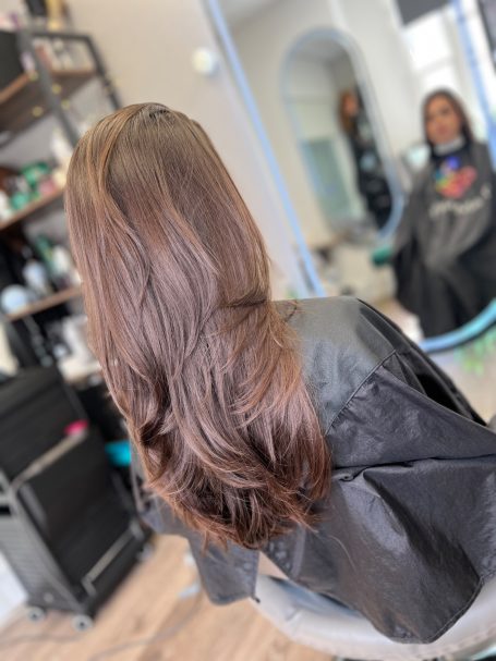 Long, wavy hair styled and draped over the shoulders, reflected in a mirror.