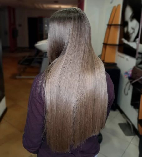 Long, straight hair cascading down a person's back in a salon setting.